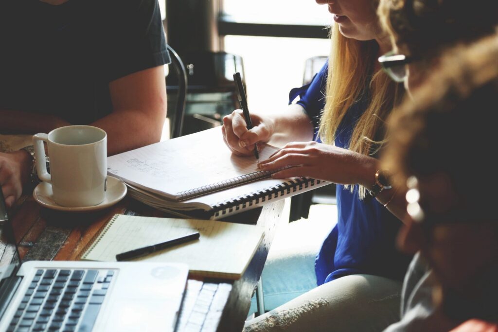 People around a table with note books.