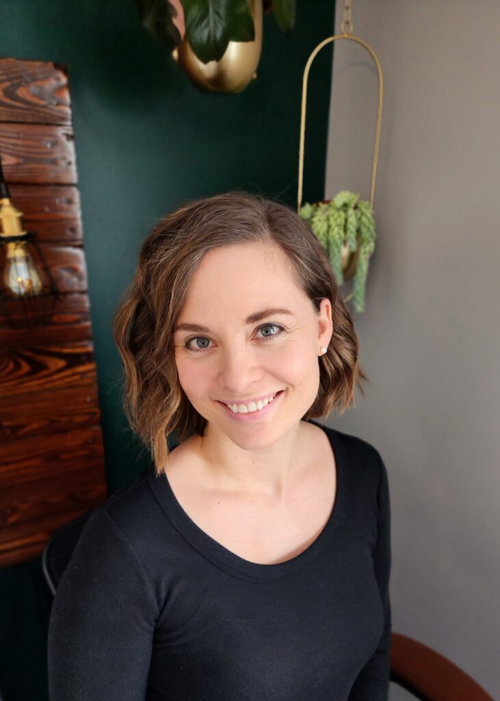 Picture of white woman with medium length brown hair, wearing a black shirt.